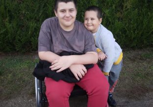 chłopiec na wózku inwalidzkim z młodszym bratem