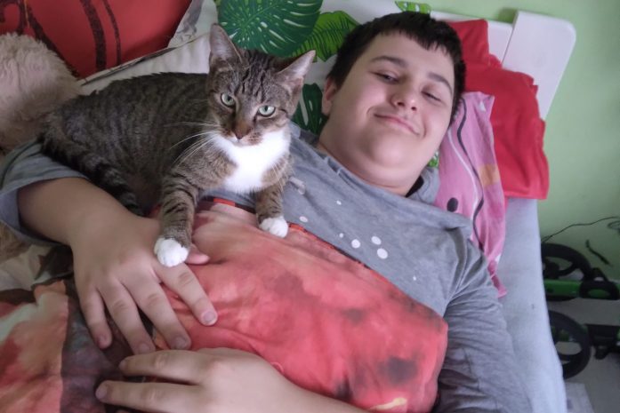 chłopiec w łóżku z kotem