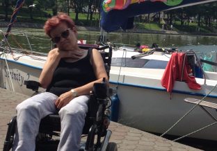 Kobieta na elektrycznym wózku inwalidzkim na tle jeziora